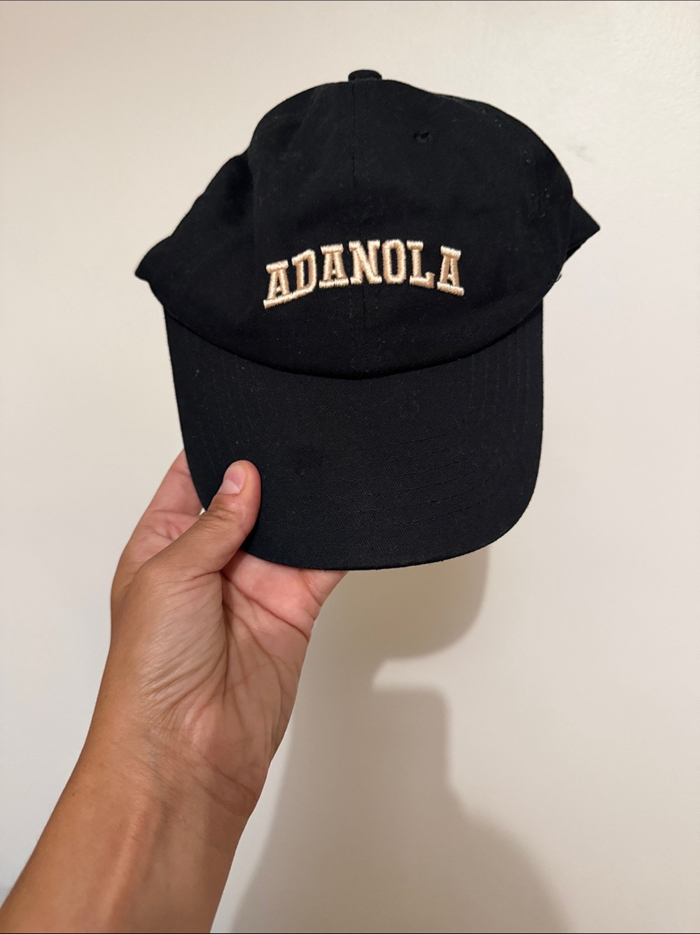 Andola black ball cap with cream embroidery lettering